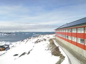 Et billede af en bygning tæt på den grønlandske kyst