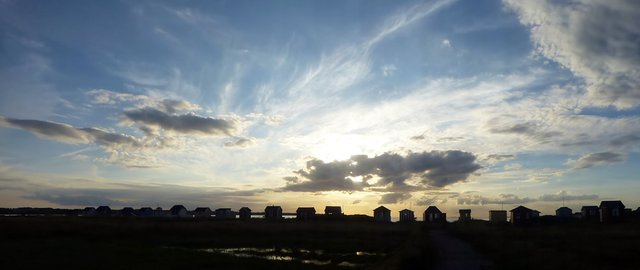 Sol og skyer over strand