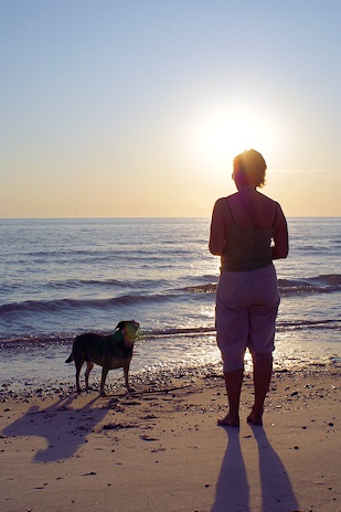 Kvinde og hund på strand