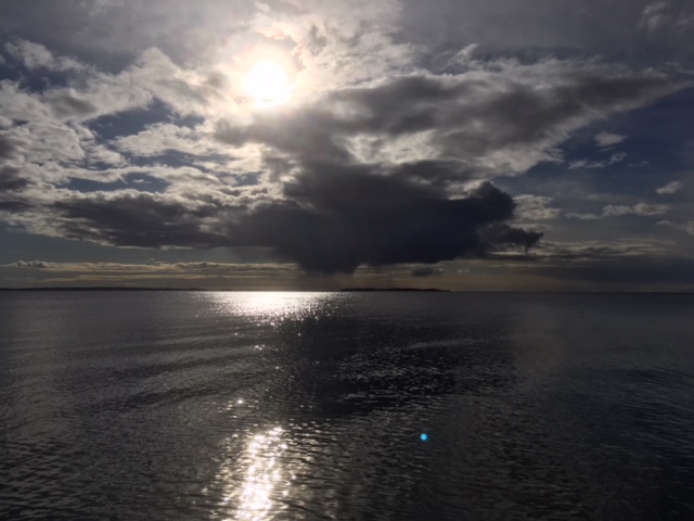Sol og skyer over havet