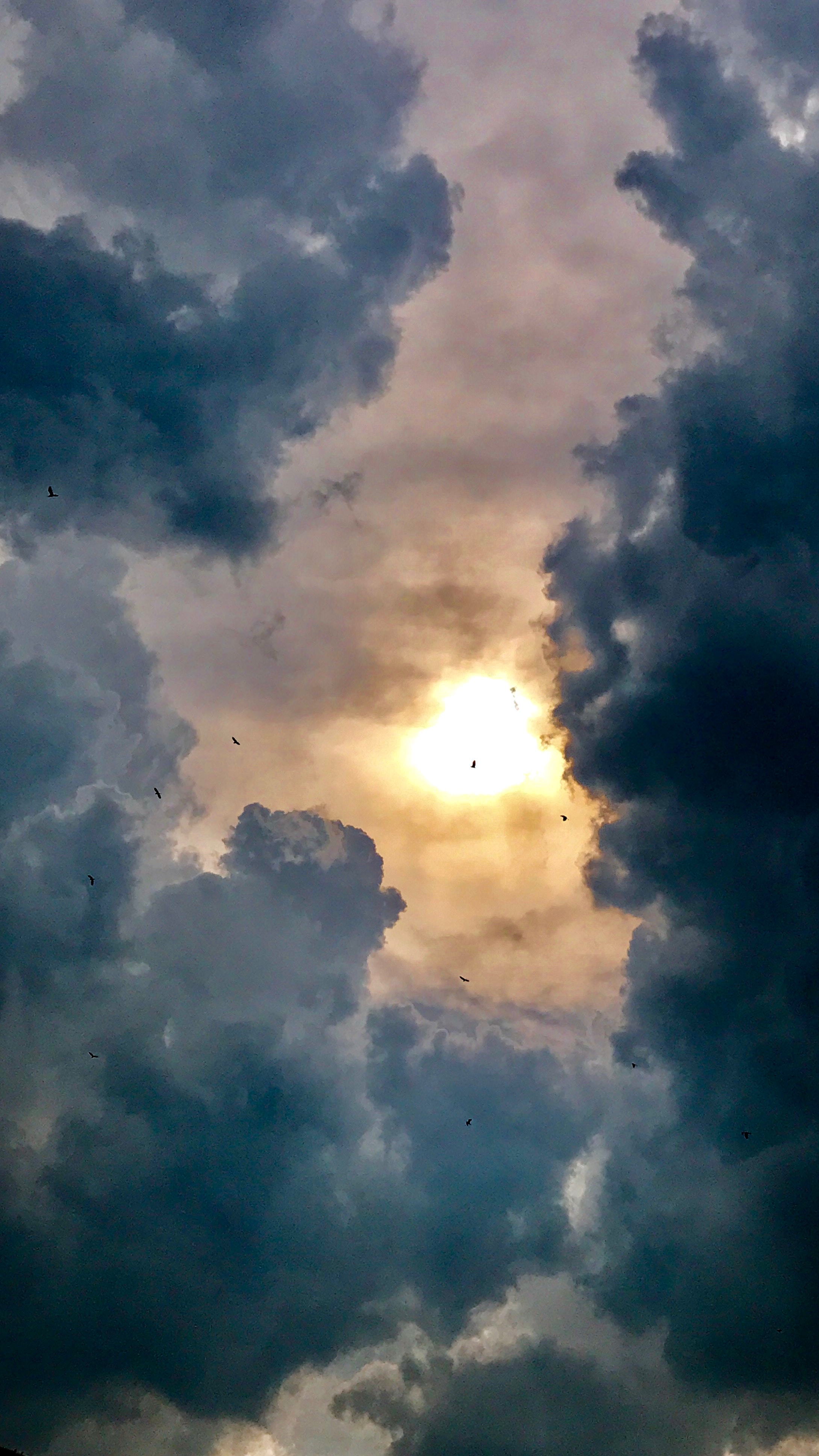 Mørke skyer på himmel med sol i baggrunden